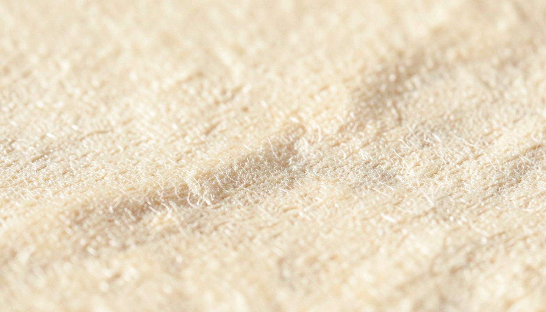 Warm cream-colored textured paper surface with subtle fibrous grain, soft beige tones, and gentle organic undulations